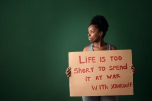 woman looking afar while holding a cardboard